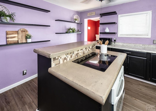 kitchen with open shelves, light countertops, dark wood-type flooring, a kitchen island, and black appliances