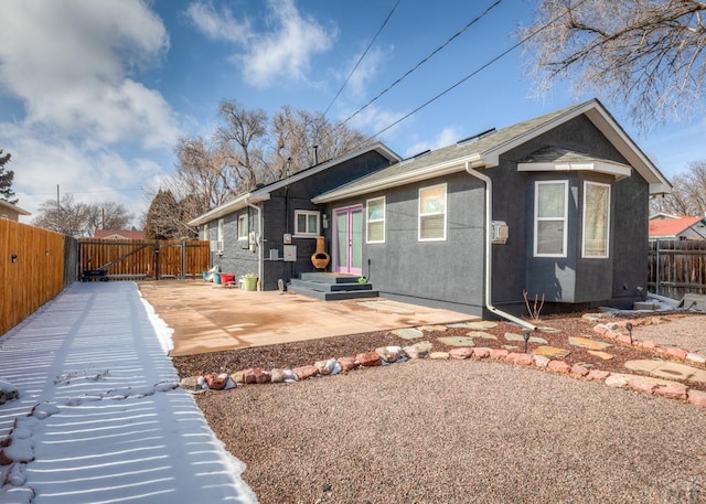 exterior space with a patio area, fence, and stucco siding