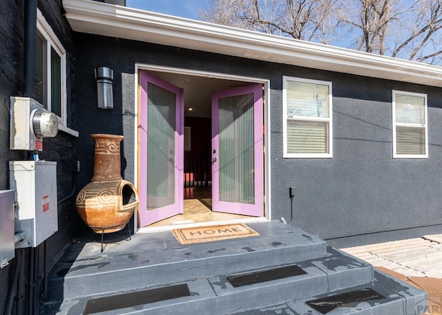 view of exterior entry featuring stucco siding