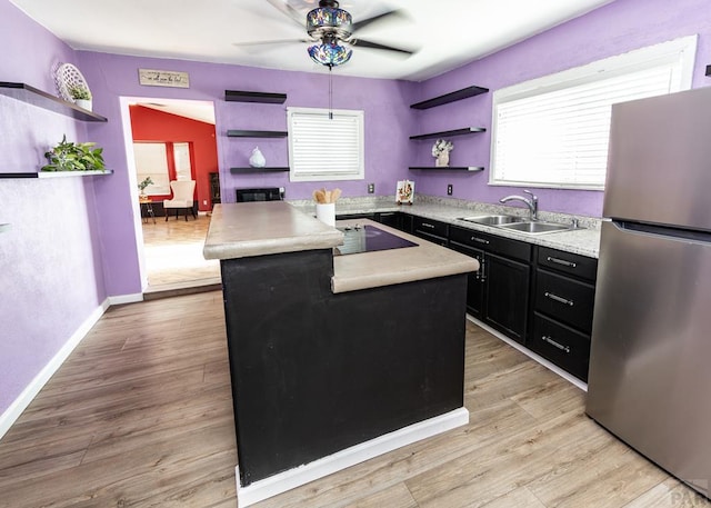 kitchen with light countertops, open shelves, a kitchen island, and freestanding refrigerator