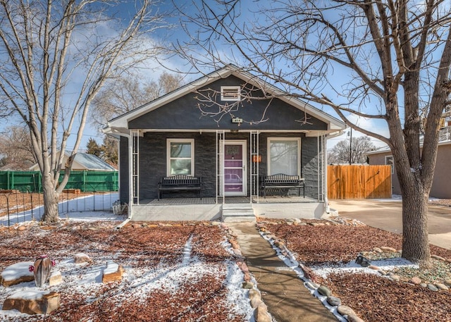 bungalow with covered porch and fence