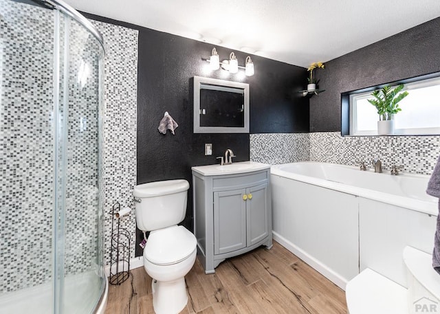 full bathroom featuring toilet, a shower stall, wood finished floors, and vanity