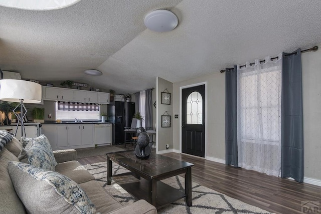 living area with lofted ceiling, a textured ceiling, baseboards, and dark wood-type flooring