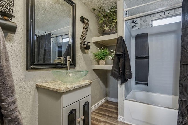 bathroom with shower / bath combination with curtain, a textured wall, vanity, a textured ceiling, and wood finished floors