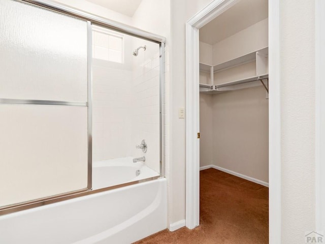 3933 Elk Ln, Pueblo, CO 81005 - bathroom featuring baseboards, enclosed tub / shower combo, and a walk in closet