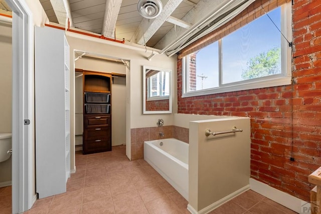 201 Lamkin Unit 205, Pueblo, CO 81003 - bathroom featuring a garden tub, brick wall, tile patterned floors, and beamed ceiling