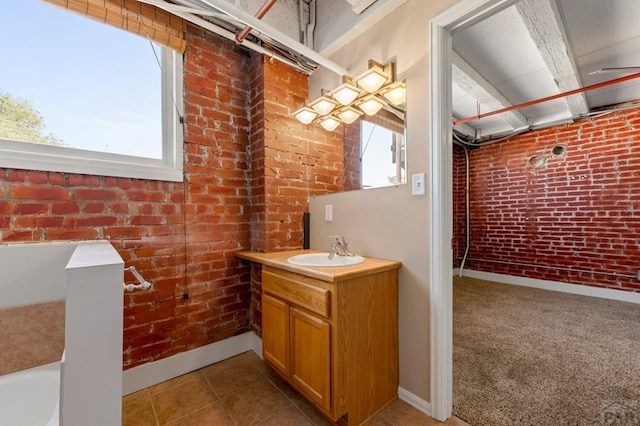 201 Lamkin Unit 205, Pueblo, CO 81003 - bathroom featuring brick wall, vanity, tile patterned floors, and a tub to relax in