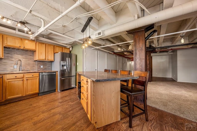 201 Lamkin Unit 205, Pueblo, CO 81003 - kitchen featuring appliances with stainless steel finishes, a kitchen breakfast bar, tasteful backsplash, and dark wood-type flooring