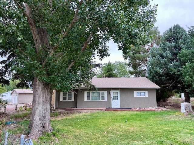 single story home with fence, a front lawn, and stucco siding