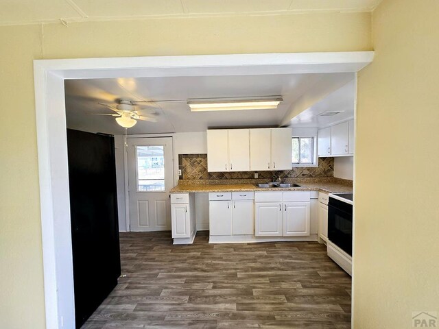 kitchen with white cabinets, dark wood finished floors, backsplash, and electric range oven