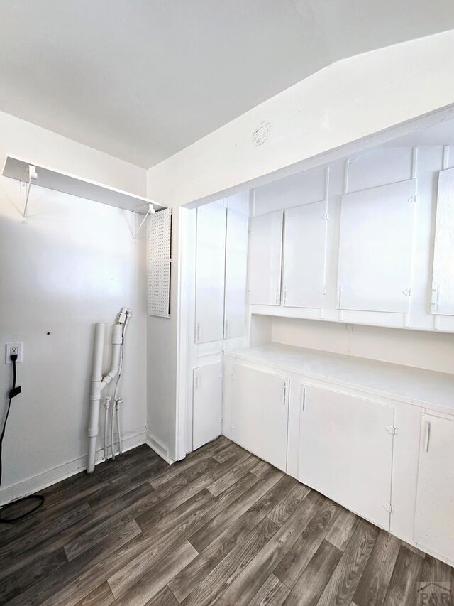 laundry room with dark wood finished floors and baseboards