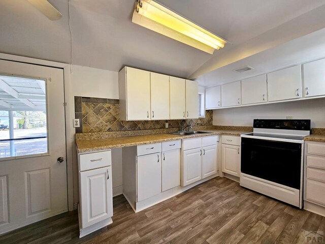 kitchen featuring dark wood-style floors, electric stove, visible vents, white cabinetry, and vaulted ceiling