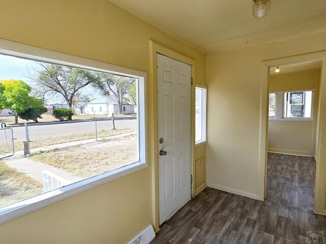 entryway with dark wood-type flooring, visible vents, and baseboards