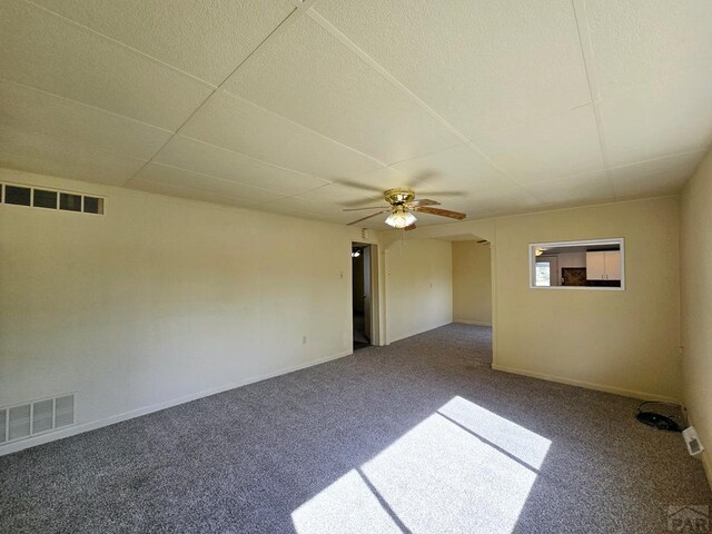 unfurnished room with carpet, visible vents, arched walkways, and baseboards