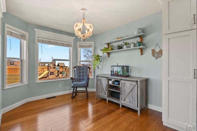 1153 E Kirkwood Dr, Pueblo, CO 81007 - living area with a chandelier, wood finished floors, baseboards, and plenty of natural light