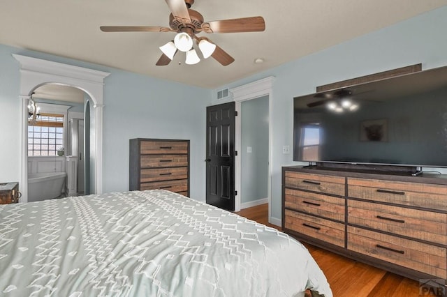 1153 E Kirkwood Dr, Pueblo, CO 81007 - bedroom featuring ceiling fan, arched walkways, wood finished floors, and visible vents