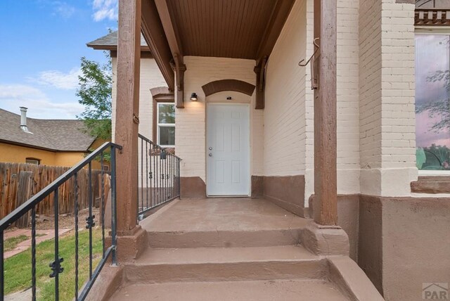 entrance to property featuring brick siding