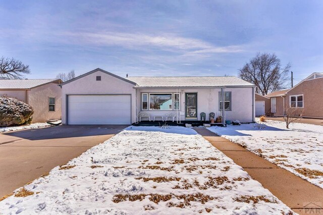 view of front facade featuring driveway, an attached garage, and stucco siding