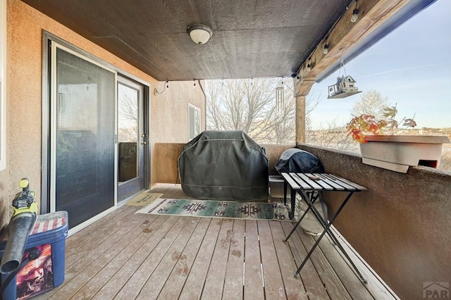 wooden deck featuring a grill