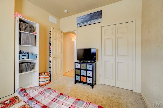 bedroom featuring light carpet, a closet, and visible vents