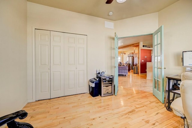 bedroom featuring light wood-style flooring, a ceiling fan, a closet, and french doors