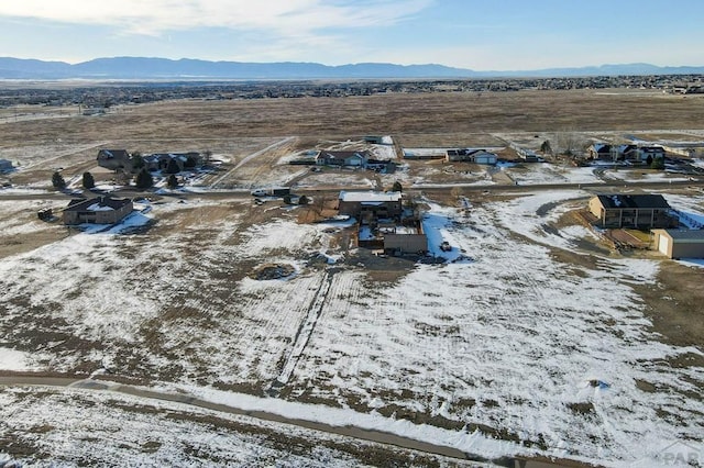 snowy aerial view with a residential view and a mountain view