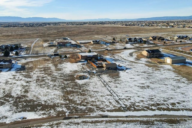 snowy aerial view featuring a residential view and a mountain view