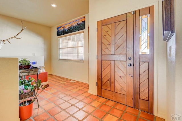 foyer entrance with baseboards and recessed lighting