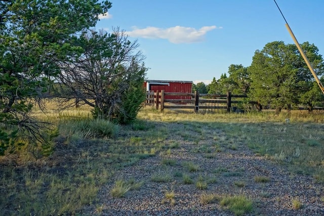 view of yard with fence and a rural view