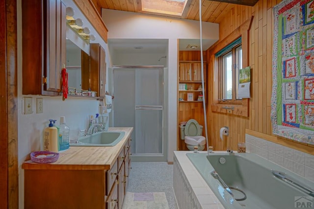 full bath featuring wood walls, a shower stall, a garden tub, and vanity