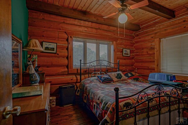 bedroom featuring beamed ceiling, wooden ceiling, wood finished floors, and log walls