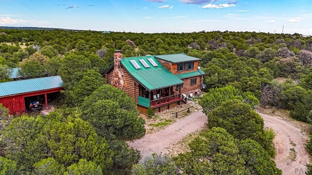 birds eye view of property featuring a view of trees