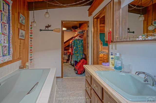 full bath featuring a garden tub, a spacious closet, and vanity