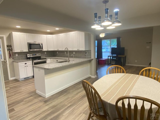 kitchen with white cabinets, stainless steel appliances, decorative backsplash, and a sink