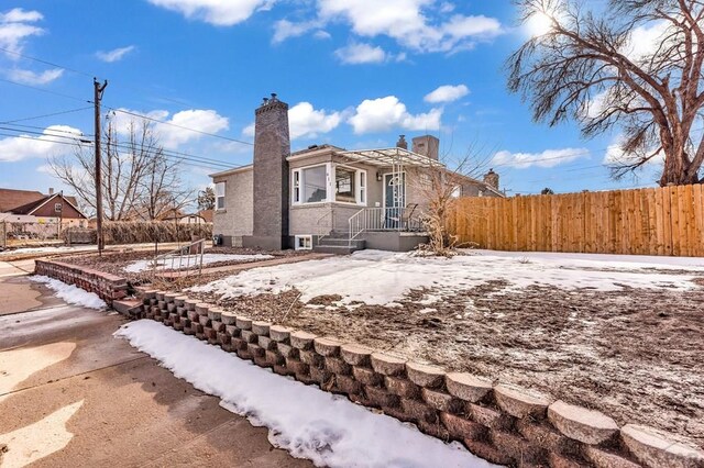 exterior space with fence and a chimney