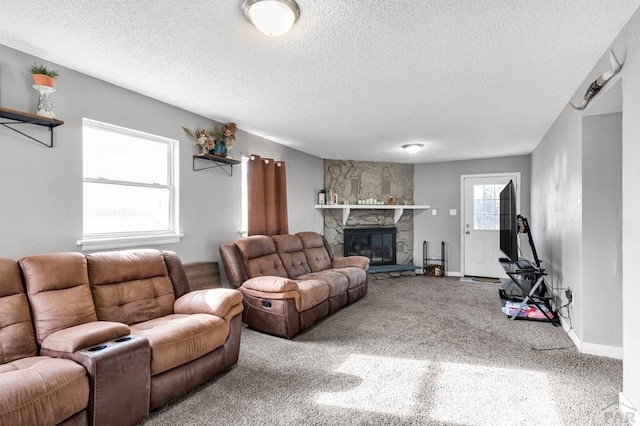 carpeted living area with a textured ceiling, a fireplace, and baseboards