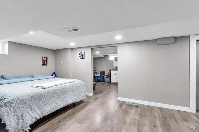 bedroom featuring light wood-type flooring, baseboards, visible vents, and recessed lighting