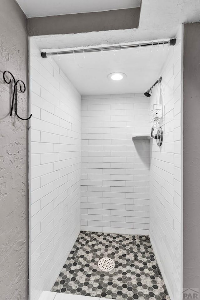 bathroom featuring a stall shower and a textured wall