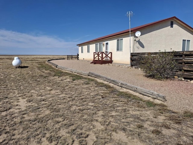 back of house with fence and stucco siding