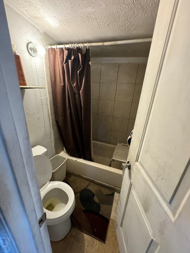 1718 E Abriendo Ave, Pueblo, CO 81004 - bathroom featuring tiled shower, a textured ceiling, and toilet