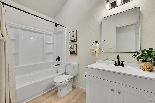 full bath with toilet, vanity, shower / bath combo, wood finished floors, and baseboards