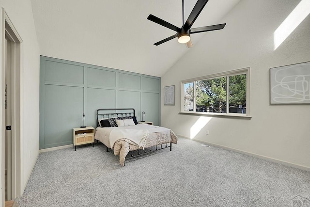 carpeted bedroom featuring baseboards, high vaulted ceiling, and ceiling fan