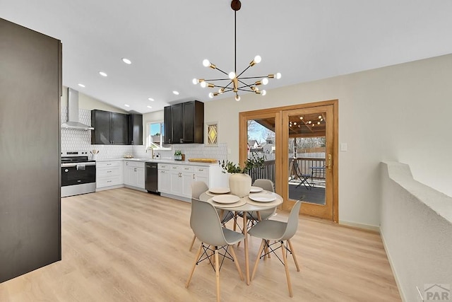 dining space with lofted ceiling, light wood-style flooring, a chandelier, and recessed lighting