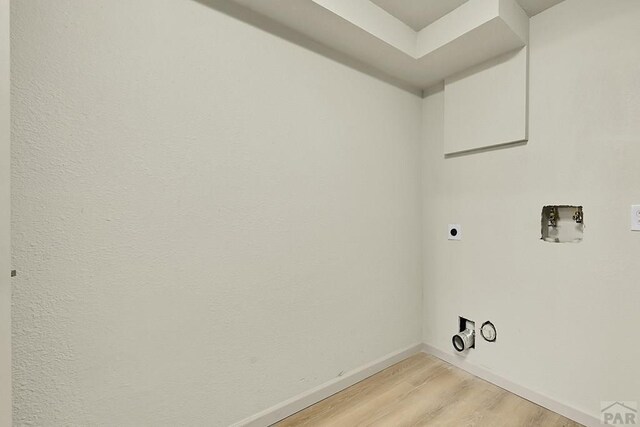 laundry area featuring light wood finished floors, electric dryer hookup, laundry area, baseboards, and hookup for a washing machine