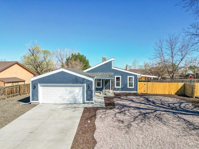 mid-century inspired home with driveway, a garage, and fence