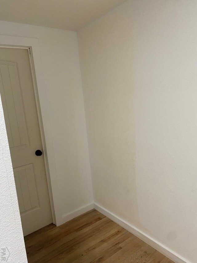 unfurnished room with light wood finished floors and baseboards