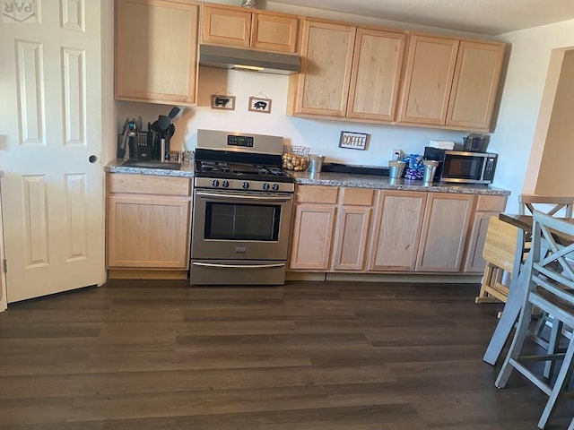 kitchen featuring appliances with stainless steel finishes, dark wood-style flooring, light brown cabinets, and under cabinet range hood