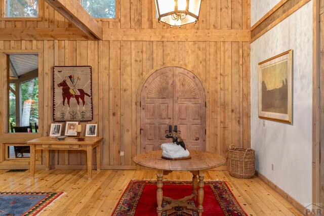 interior space with wood walls, baseboards, and wood finished floors