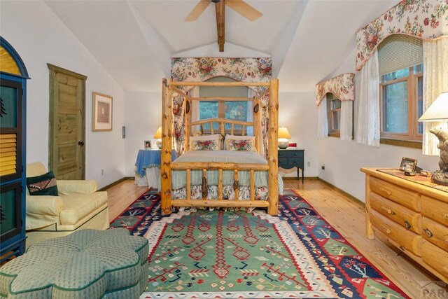 bedroom with a ceiling fan, vaulted ceiling with beams, baseboards, and wood finished floors