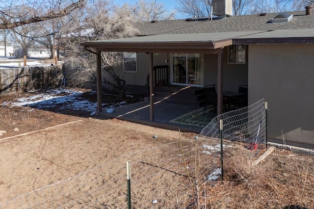 back of house with roof with shingles and fence